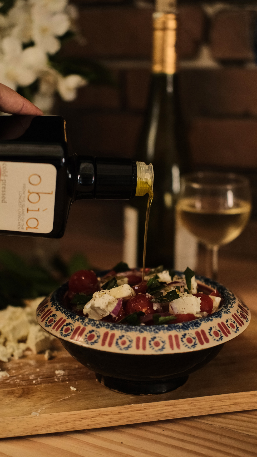 obia olive oil pouring onto mediterranean salad